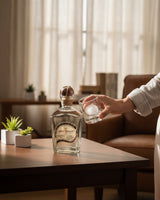 Botella de Licomar, Vinos y Licores Sotol Cinco Tragos Blanco 750ml con un vaso de hielo en una mesa de madera.