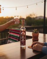 Botella de Sotol Flor del Desierto Carne 750ml de Licomar, Vinos y Licores, con vaso y manta mexicana al atardecer.
