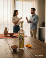 Botella de sotol Flor del Desierto Sierra 750ml, triple destilado, orgánico USDA, con rodajas de naranja y aperitivos.