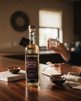 Botella de Licomar, Vinos y Licores Sotol Pizcadores Añejo 750ml de color cobrizo brillante con etiqueta morada y dorada.