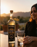 Botella de Licomar, Vinos y Licores 100% Sotol Reposado 750ml con vaso y hielo al atardecer. Notas a roble, cítricos y agave cocido.